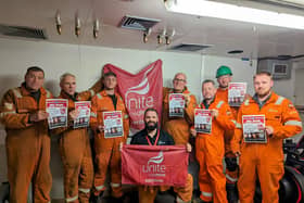 Offshore workers at Ninian Central platform with posters backing Unite the Union's No Ban Without a Plan campaign.