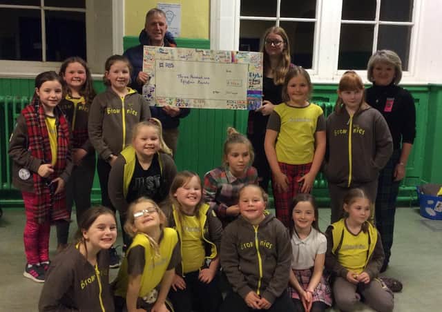 Selkirk Brownies are pictured handing over a £354 cheque to Tweed Valley Mountain Rescue team member Gavin Kellett in Selkirk’s Argus Centre.The cash was raised via a sponsored fitness challenge night.
