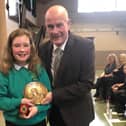 Emily Johnstone of Balmoral primary school became the first recipient of the Robert Burns Quaich, donated by Galashiels Burns Club, for best overall performance at the 12th annual Eildon West Learning Community; Celebration of Scots Language and Culture held at Langlee Community Centre Her victories, coupled with her schoolmates’ successes, ensured that Balmoral were awarded the 2020 Scots Language Trophy. She is pictured with Alistair Christie, of Galashiels Burns Club.