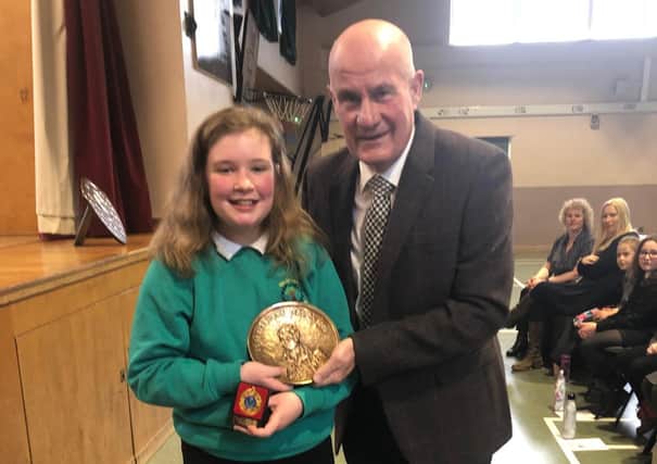 Emily Johnstone of Balmoral primary school became the first recipient of the Robert Burns Quaich, donated by Galashiels Burns Club, for best overall performance at the 12th annual Eildon West Learning Community; Celebration of Scots Language and Culture held at Langlee Community Centre Her victories, coupled with her schoolmates’ successes, ensured that Balmoral were awarded the 2020 Scots Language Trophy. She is pictured with Alistair Christie, of Galashiels Burns Club.