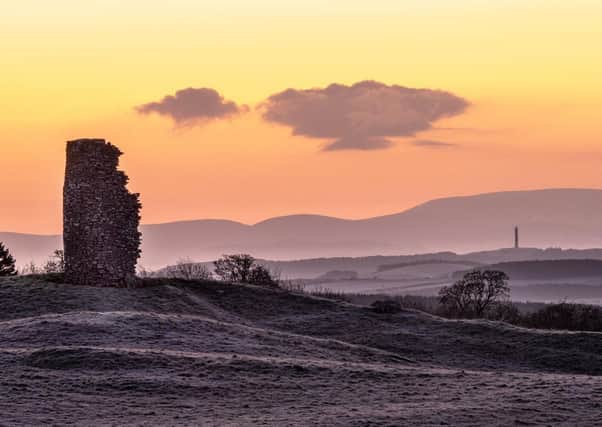 A ruined windmill and Peniel Heugh monument against a backdrop of the Cheviot Hills are captured on a frosty morning prior to sunrise