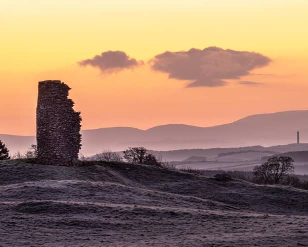A ruined windmill and Peniel Heugh monument against a backdrop of the Cheviot Hills are captured on a frosty morning prior to sunrise