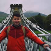 Walking Britain's Lost Railways presenter Rob Bell on the Melrose chain bridge over the River Tweed.