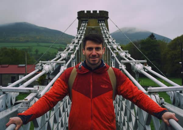 Walking Britain's Lost Railways presenter Rob Bell on the Melrose chain bridge over the River Tweed.