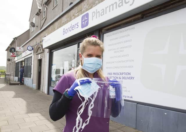 Borders Pharmacy counter assistant Alex Hay with the PPE kit the business is giving away, comprising gloves, face mask and visor and hand sanitiser.