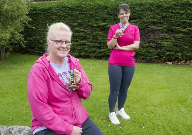 Donna Robson and Melissa Page in Bongate in Jedburgh with their fundraising half-marathon medals.