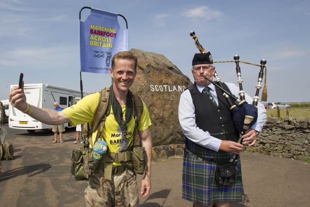 Army major Chris Brannigan arrives at Carter Bar bound for Jedburgh on the latest leg of his 700-mile barefoot fundraising walk from Cornwall to Edinburgh, piped into the country by Hawick piper Allan Smith.