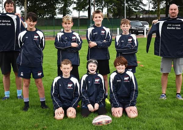 Last season’s Selkirk Rhinos P7 players in their sponsored tour tops, flanked by coaches Douglas Smith (left) and Jamie Thomson.