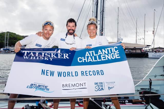Taylor Winyard, right, celebrates Atlantic Nomads' world record row with crewmates Tom Rose and James Woolley.