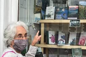 Carol Beveridge points to the book in a bookshop window.
