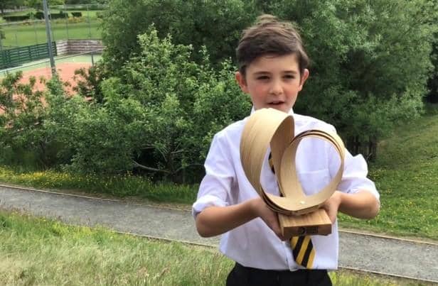Primary four pupil Hector French with the Surfers Against Sewage trophy.