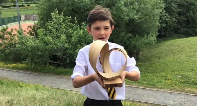Primary four pupil Hector French with the Surfers Against Sewage trophy.