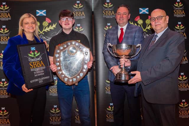 Ryan Borthwick being presented with the awards from representatives from the Scottish Brass Band association along with the adjudicators.
