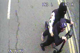 ​This CCTV image shows two young people riding an e-scooter directly behind a Borders bus.