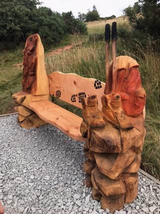 The beautiful bench has John's trademark boots, poles and rucksack.