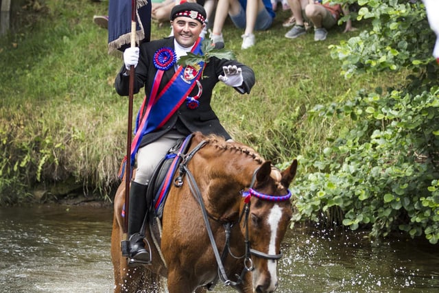 Jethart Callant Gregor Paxton fording the river Jed on Festival Day and acknowledging the crowds.