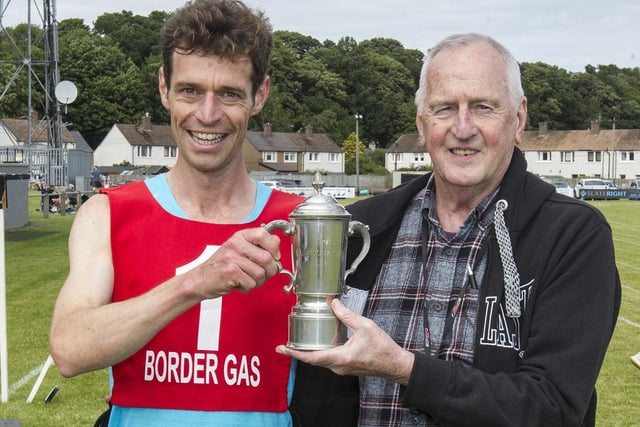 Kelso's Darrel Hastie, winner of the 1,600m open at his home-town's Border Games, being presented with the prize for best performance of the day by Ernie Blair
