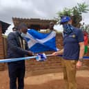 President Daniel Dunga of the Rotary Club of Limbe, Malawi, cuts the ribbon to officially open the new incinerator, alongside Denis Robson.