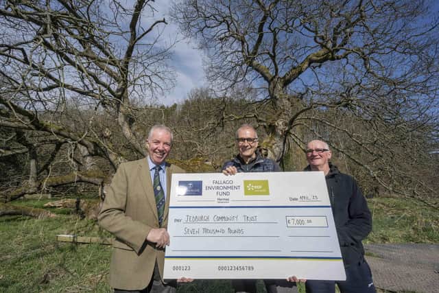 Gareth Baird presents Jim Steele with the cheque for £7,000 to help pay for work to preserve the Capon Tree, watched by Brian Chicklewoods from Jedburgh Community Council. Photo: Phil Wilkinson.