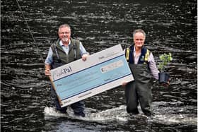 Tweed Forum director Luke Comins receives a cheque for £4,572 from FishPal CEO Mark Cockburn. Photo: Paul Dodds.
