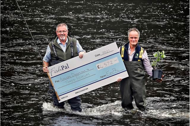Tweed Forum director Luke Comins receives a cheque for £4,572 from FishPal CEO Mark Cockburn. Photo: Paul Dodds.