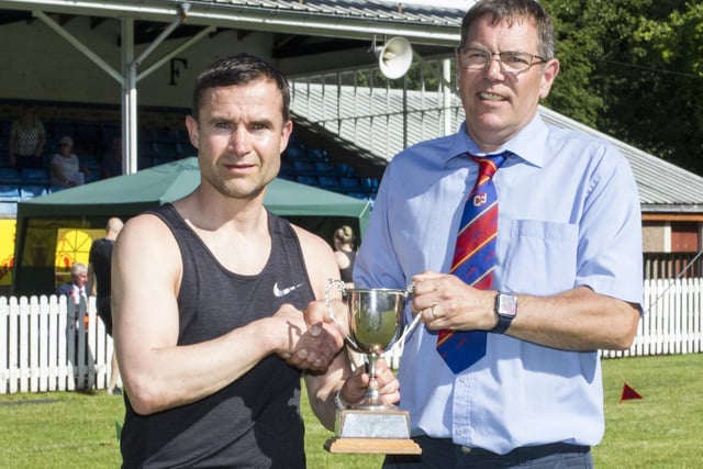 Hawick's David Lauder being given his trophy for winning the 90m veterans' sprint handicap