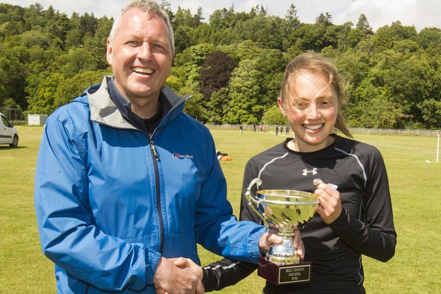 Charlotte Clare being presented with the trophy for winning the 800m open race at Hawick Border Games