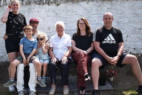 Anne Oliver on a new bench at Selkirk Cricket Club's home ground in memory of her late husband George, with daughter Joyce, grandsons Blaine, left, and Fraser Gillie and Blaine’s wife Rachel and their children Michael and Katie (Pic: John Smail)