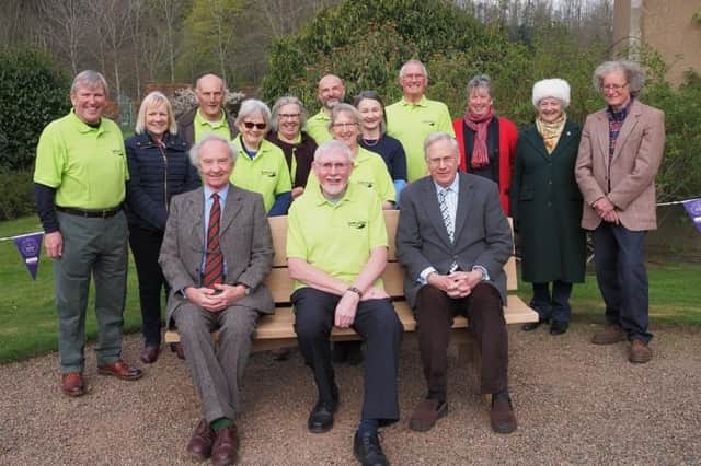 From left, the Duke of Buccleuch, Ian Gibb and the Duke relax on the new bench as members of the paths group look on. Photo: Curtis Welsh.