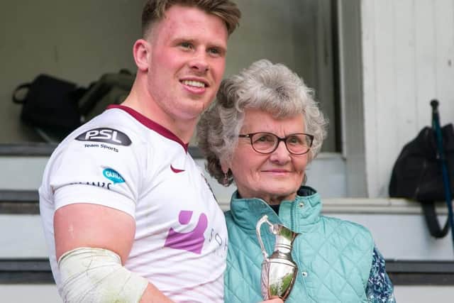 Mary Callander presenting a Kelso Sevens player of the tournament trophy to Watsonians’ Lewis Berg. Photo: Gavin Horsburgh