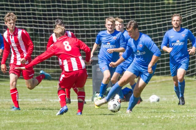 Owen Cranston on the ball for Ancrum, in blue, who went down heavily to Tweedside Rovers (picture by Bill McBurnie)