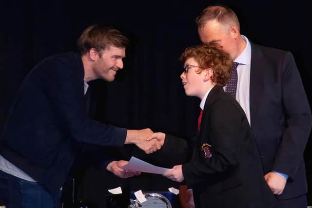James presents a certificate to S1 pupil Owen Clotworthy.