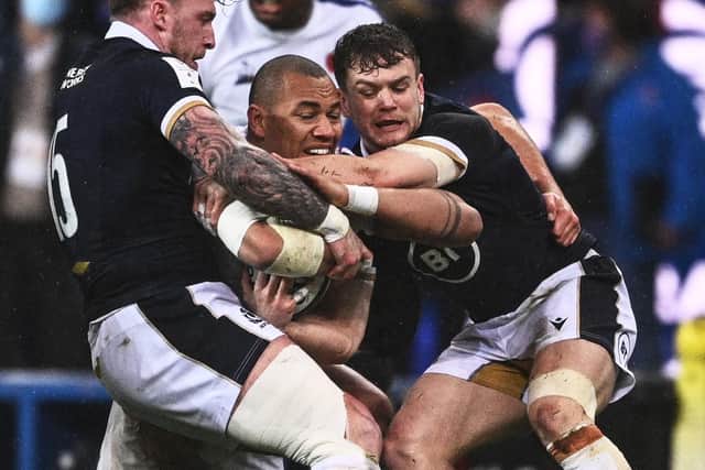 France's Gael Fickou being tackled by Scotland's Stuart Hogg and Darcy Graham (Photo by ANNE-CHRISTINE POUJOULAT/AFP via Getty Images)