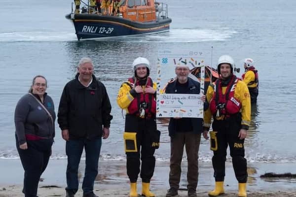 RNLI Lifeguards stop to receive their Co-op local cause award at Eyemouth Beach.