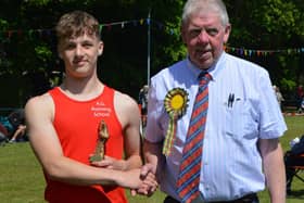 Kelso's Daniel Lawson being presented with one of the two first prizes he won at Sunday's Markinch Highland Games in Fife (Pic: Royal Scottish Highland Games Association)