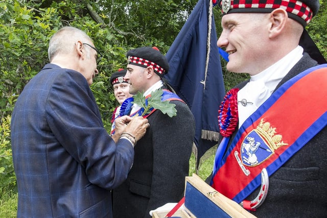 Jedburgh Callant's Club President Jim Steele pins a sprig from the Capon Tree onto Callant Gregor Paxton's Sash.