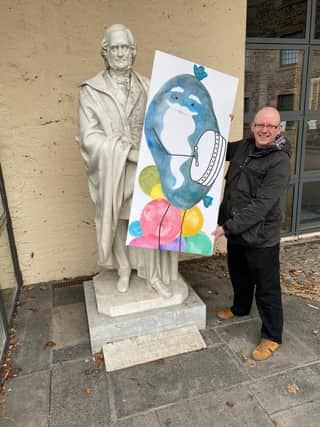 Thomas posing with the story's haggis hero in front of the James Wilson statue in Hawick.