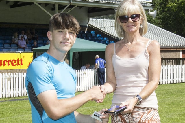 Innerleithen's Josh Landers being given his prize for winning the 90m A handicap for youths by Nichola Morrison