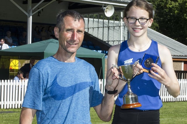 Tess Renwick, winner of the 200m youth handicap A race, being given her prize by Iain Williams