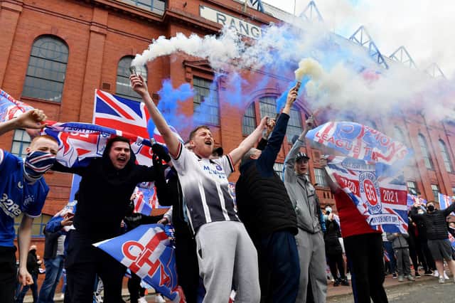 Rangers fans set off smoke bombs as they gather outside Glasgow's Ibrox Stadium to celebrate their team winning the Scottish Premiership title on March 7 (Photo by Mark Runnacles/Getty Images)