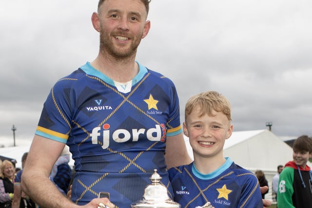 Auld Stars player Scott Wight and son Rory with Sunday's Earlston Sevens trophy (Photo: Brian Sutherland)