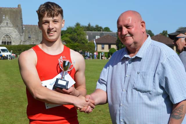 Kelso's Daniel Lawson being presented with one of the two first prizes he won at Sunday's Markinch Highland Games in Fife (Pic: Royal Scottish Highland Games Association)