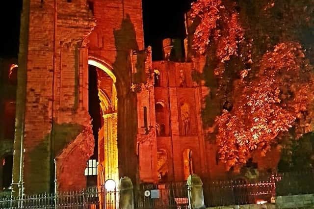 Kelso Abbey lit up in red.