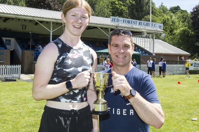Brodie Cowan being given the prize  for winning the ladies' 100m handicap by Owen Stewart
