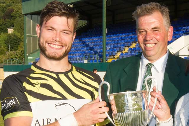 Hawick Rugby Club president Neil Hamilton, right, presenting Melrose skipper David Colvine with the Greens' sevens winners' cup in August (Photo: Bill McBurnie)