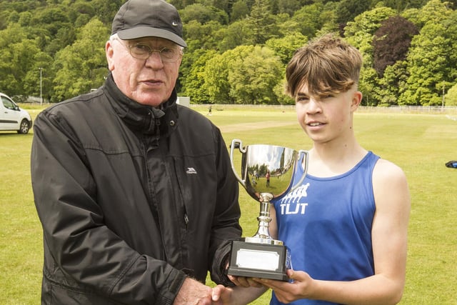 TLJT's Aaron Glendinning being presented with the 400m youth handicap winner's trophy by Archie Scott