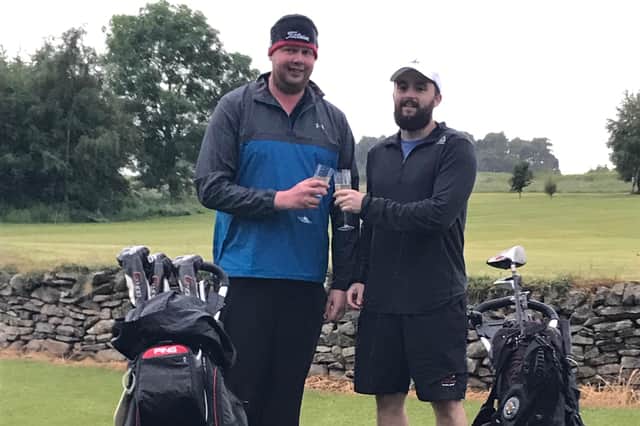 It's your round ... golfer Grant Robson, left, and his friend, Chris Frazer, toast the success of the day-long, 100-hole course challenge