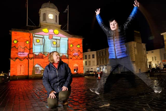 Oliver jumps for joy as his design is projected onto the town hall.