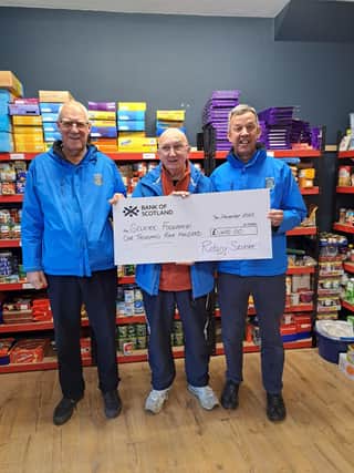Grant Gill and Les Rutherford present the cheque to Peter Birnie (centre).
