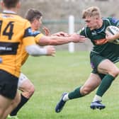Hawick's Logan Gordon-Woolley fending off a Currie challenge at the weekend (Photo: Bill McBurnie)